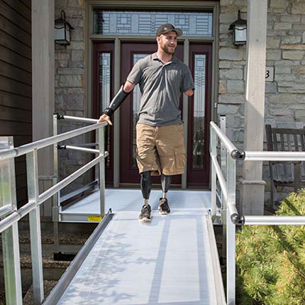 disabled man using wheelchair ramp to safely exit home