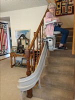 Lifeway Mobility customer riding new curved stairlift in home in Wichita KS