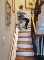 woman rides on new stairlift in home in Hanahan SC installed by Lifeway Mobility