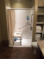 wheelchair accessible shower with shower chair and grab bars in Indiana home