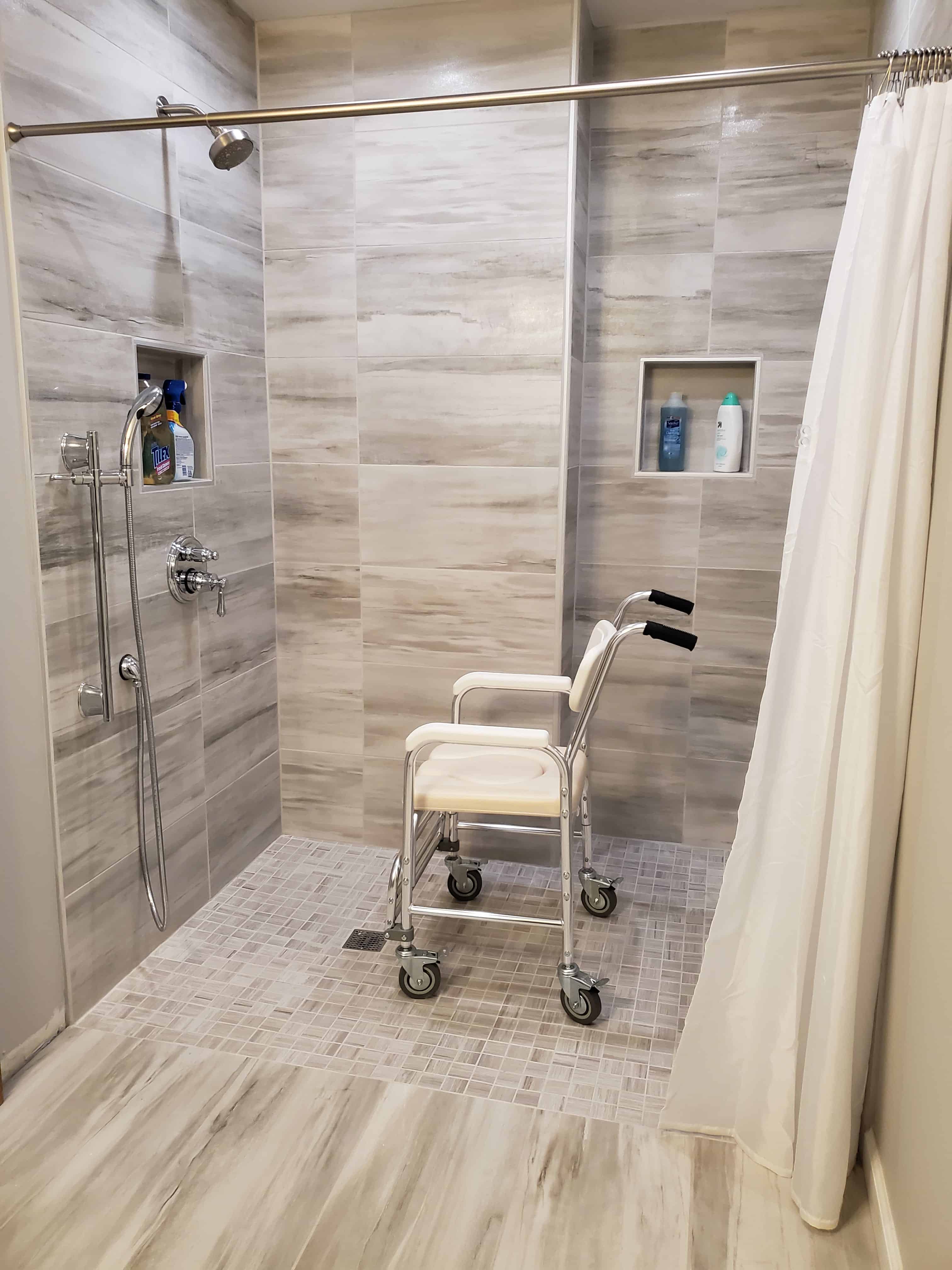 wheelchair accessible roll-in shower with shower chair in it