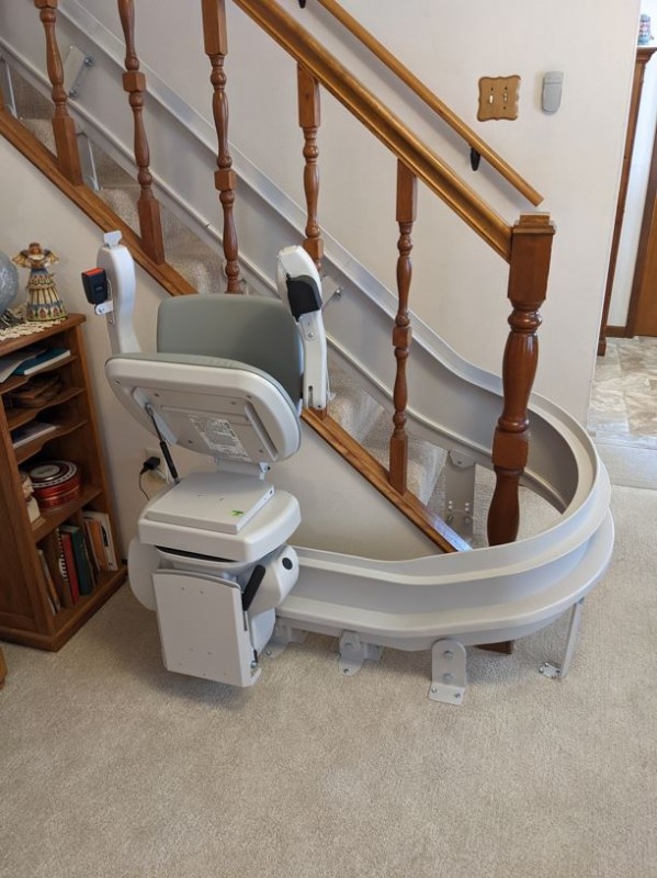 curved stairlift at bottom landing with seat folded up in Wichita KS by Lifeway Mobility