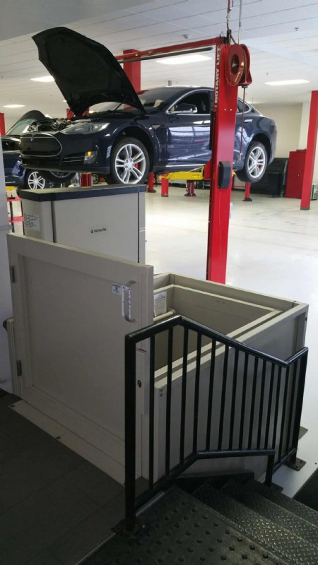 commercial-wheelchair-lift-in-Tesla-Motors-service-center-with-Tesla-vehicle-in-background.jpg
