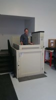 Commercial VPLs/Tesla Motors employee using EHLS installed wheelchair lift to access raised entrance